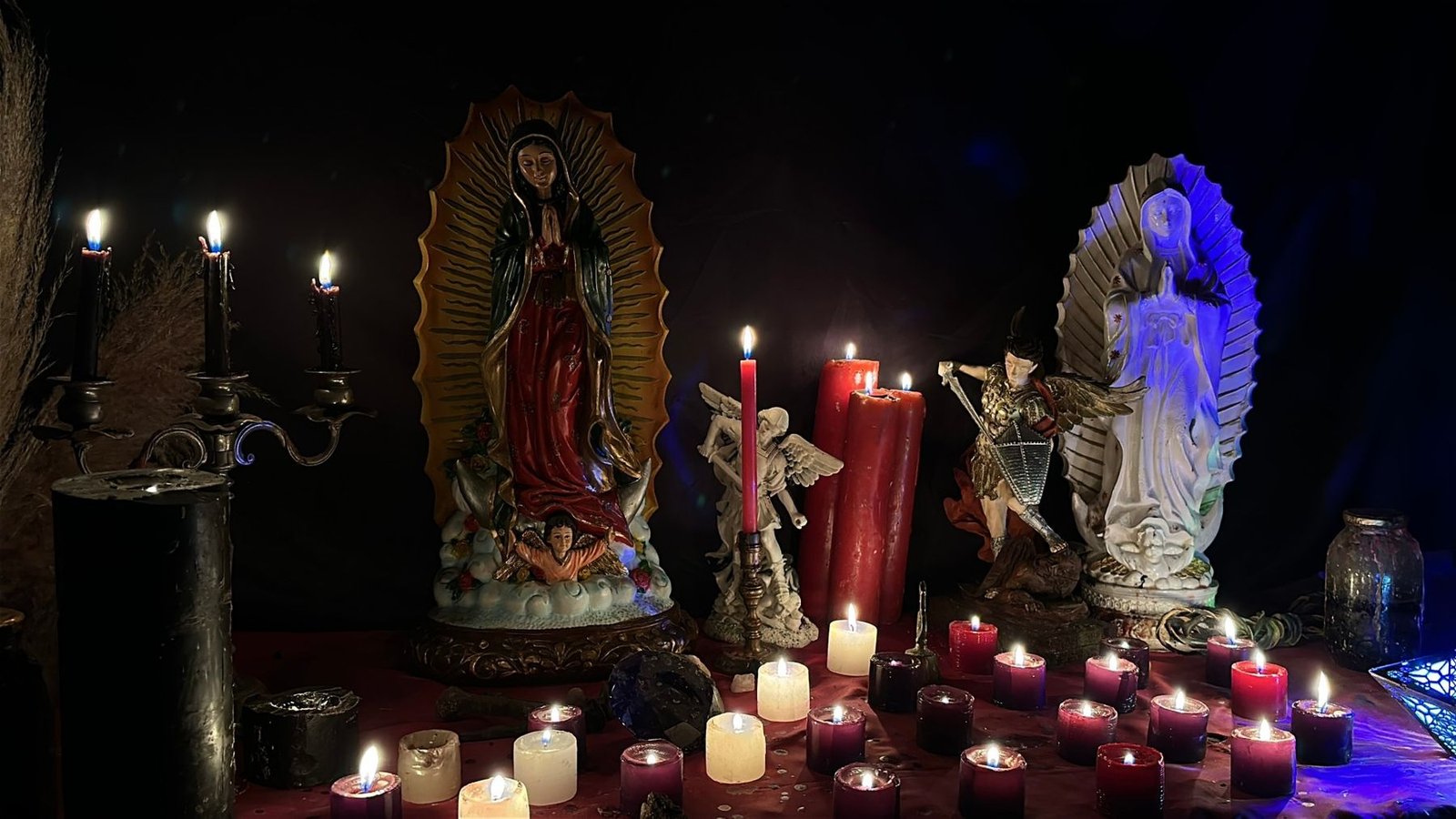 Altar del Maestro Abrecaminos con velas encendidas, la Virgen de Guadalupe y San Miguel Arcángel