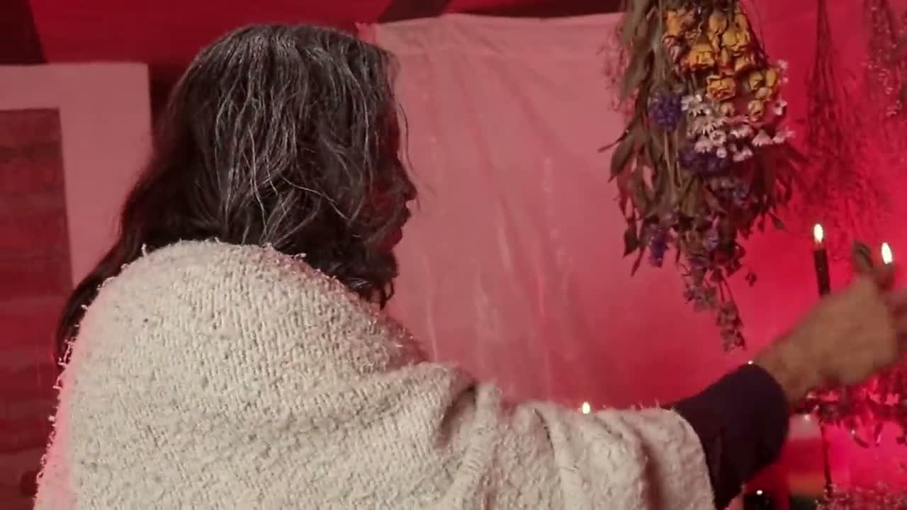 El Maestro Abrecaminos trabajando en su altar, encendiendo velas entre hierbas secas